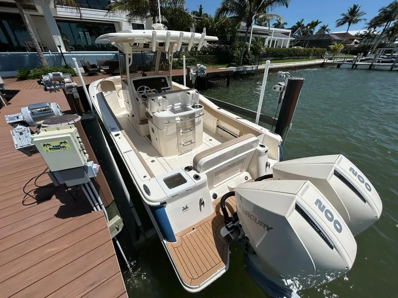 Slide: The Image of 2023 Scout 277 LXF boat docked, featuring dual Mercury engines and spacious deck. - 6