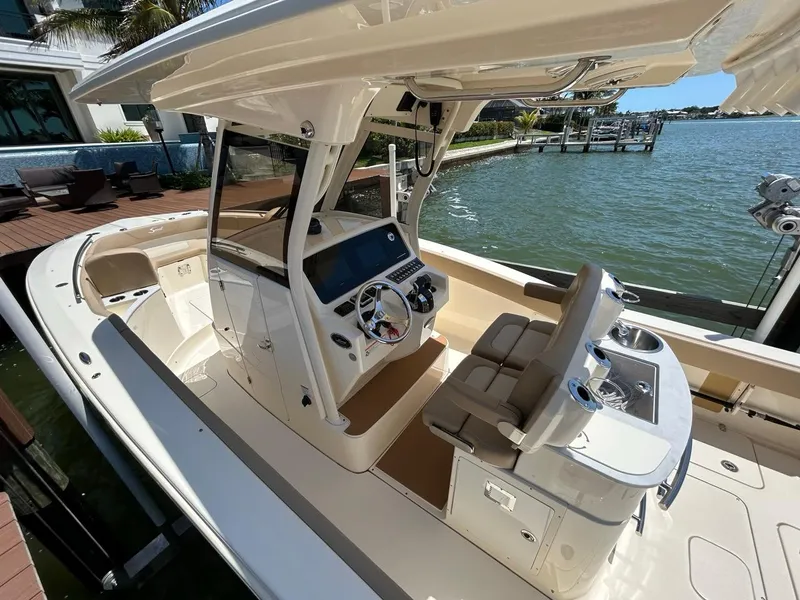 Slide: The Image of 2023 Scout 277 LXF boat with modern helm, docked by waterfront. - 7
