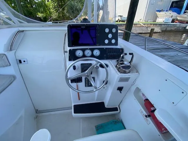 Slide: The Image of 2001 Boston Whaler 28 Conquest helm with steering wheel and navigation instruments. - 12