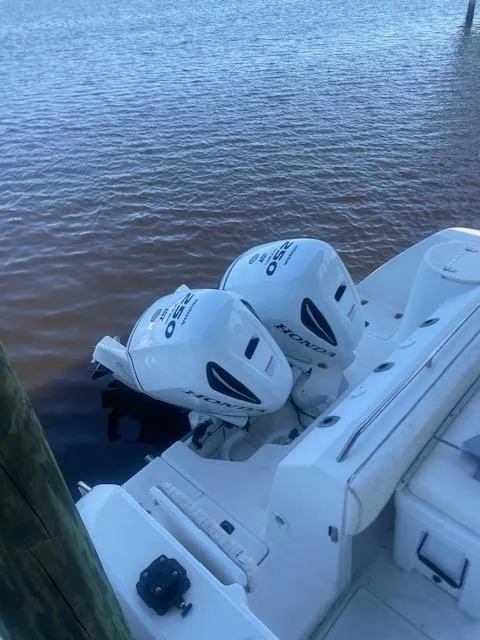 Slide: The Image of 2001 Boston Whaler 28 Conquest with twin outboard motors docked on calm water. - 14