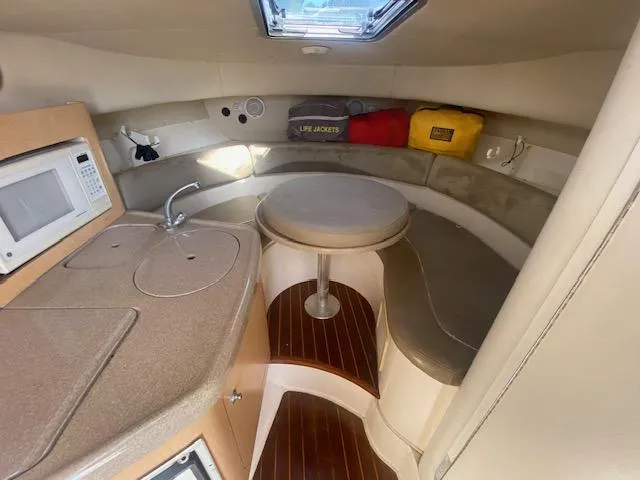 Slide: The Image of 2001 Boston Whaler 28 Conquest cabin with kitchenette, seating, and life jackets. - 17