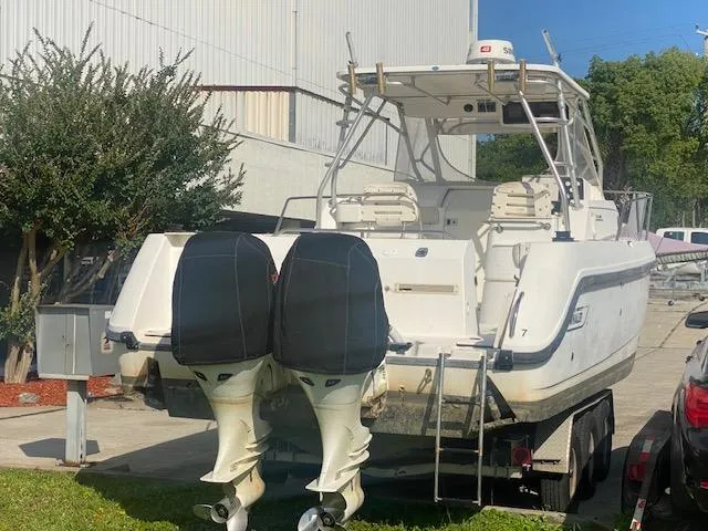Slide: The Image of 2001 Boston Whaler 28 Conquest boat with dual outboard motors on a trailer. - 2