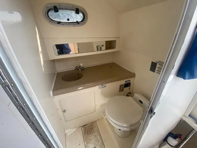 Slide: The Image of 2001 Boston Whaler 28 Conquest boat bathroom with sink, toilet, and mirror. - 21
