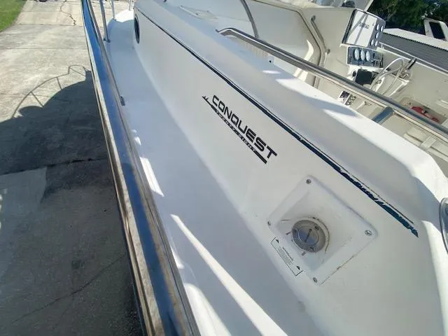 Slide: The Image of 2001 Boston Whaler 28 Conquest boat deck with railing and logo. - 25