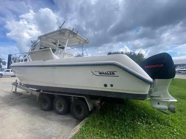 Slide: The Image of 2001 Boston Whaler 28 Conquest boat on trailer, parked outdoors under cloudy sky. - 31