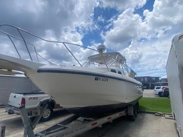 Slide: The Image of 2001 Boston Whaler 28 Conquest boat on trailer under cloudy sky. - 32