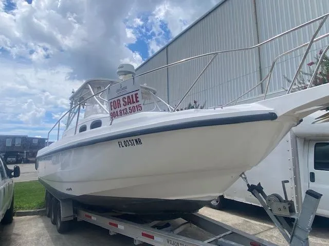 Slide: The Image of 2001 Boston Whaler 28 Conquest boat for sale on trailer, under cloudy sky. - 33