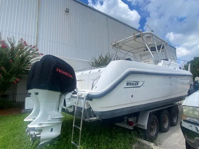 Slide: The Image of 2001 Boston Whaler 28 Conquest boat on trailer, parked outdoors near a building. - 35