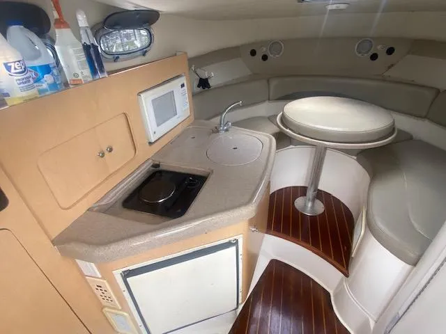 Slide: The Image of 2001 Boston Whaler 28 Conquest cabin interior with kitchenette and seating area. - 40