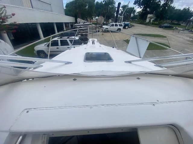Slide: The Image of 2001 Boston Whaler 28 Conquest boat deck view, parked outdoors with vehicles nearby. - 45