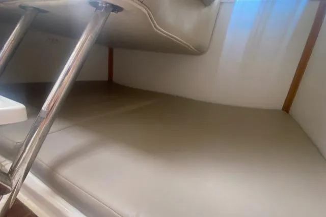 Slide: The Image of Interior cabin of 2001 Boston Whaler 28 Conquest with beige seating and metal supports. - 46