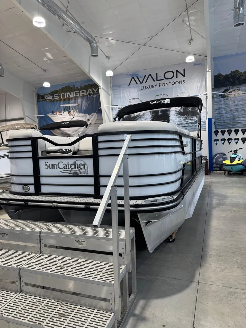 Slide: The Image of 2024 G3 Elite 324RC pontoon boat displayed in showroom with SunCatcher branding. - 2