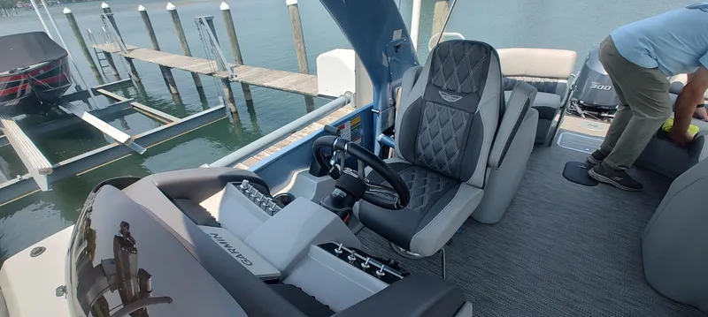 Slide: The Image of 2021 Bennington RX 25 RXFBA boat interior with steering wheel and seating at dock. - 4