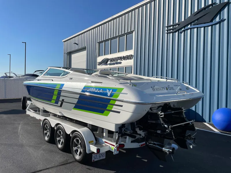 Slide: The Image of 2018 Formula 292 FASTech boat on trailer, parked outside a blue building. - 1