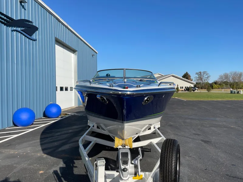 Slide: The Image of 2018 Formula 292 FASTech boat on trailer, parked outside blue building under clear sky. - 3