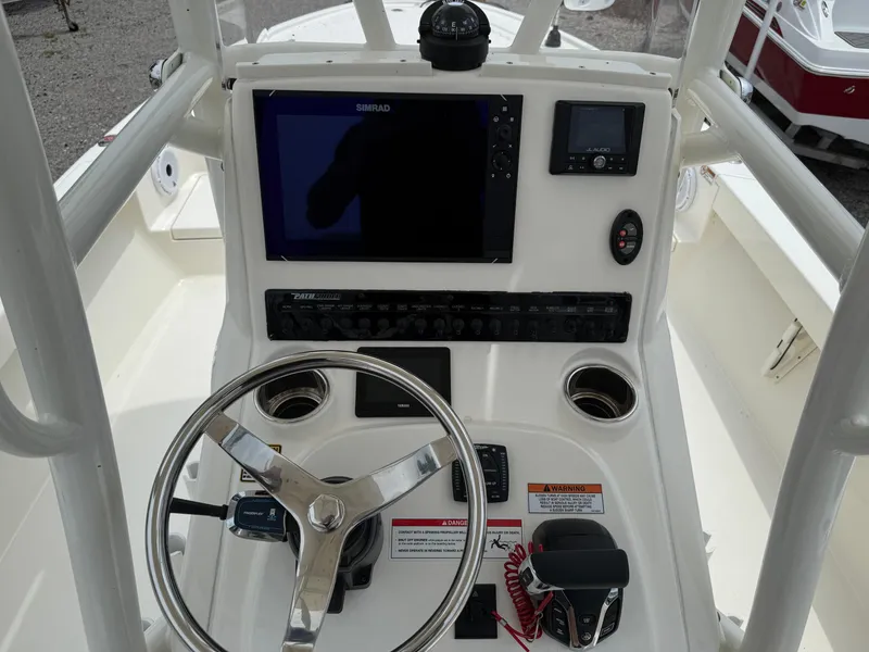 Slide: The Image of 2023 Pathfinder 2500 Hybrid boat console with steering wheel, navigation screens, and controls. - 26