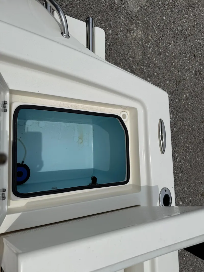 Slide: The Image of 2023 Pathfinder 2500 Hybrid boat livewell, open lid, blue interior, on textured surface. - 33