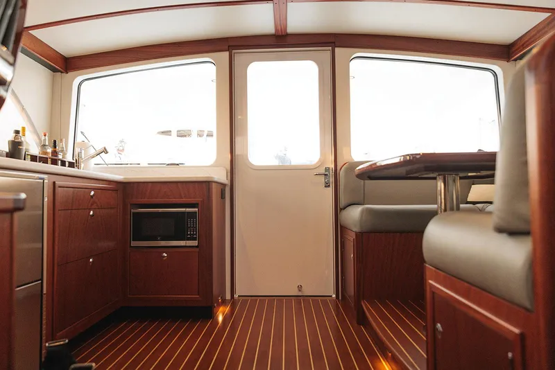 Slide: The Image of Interior of 2022 Composite Yacht CY46, featuring wood cabinetry and seating. - 18