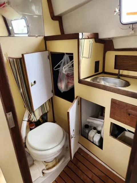 Slide: The Image of 1977 Bombay Express boat bathroom with toilet, sink, and storage cabinets. - 11