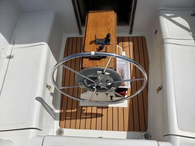 Slide: The Image of Steering wheel of a 1977 Bombay Express sailboat with wooden deck details. - 3