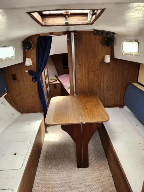 Slide: The Image of Interior of a 1977 Bombay Express sailboat with wooden table and seating. - 5