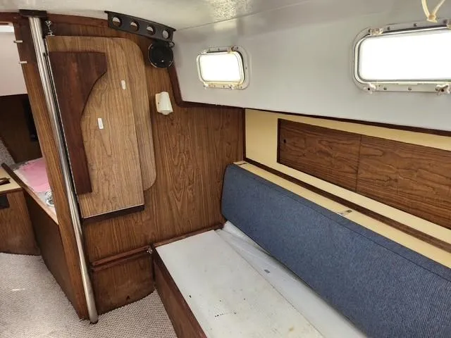 Slide: The Image of Interior of a 1977 Bombay Express boat with wood paneling and blue seating. - 6
