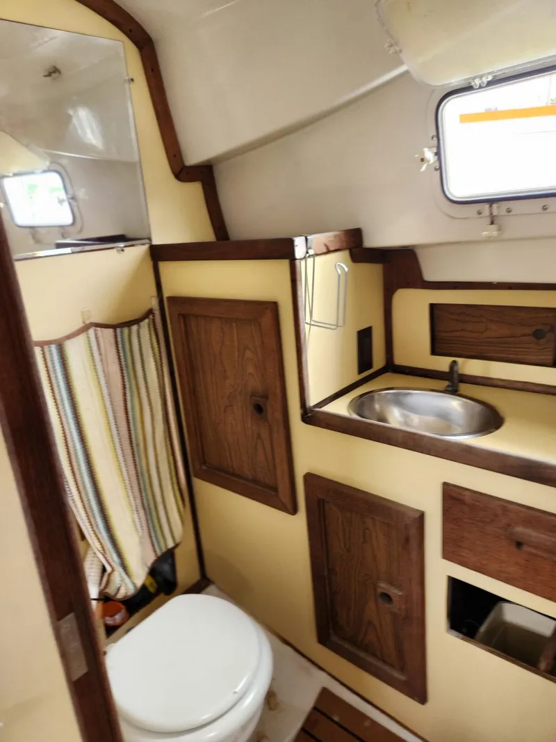 Slide: The Image of 1977 Bombay Express boat bathroom with wooden cabinets and compact sink. - 7