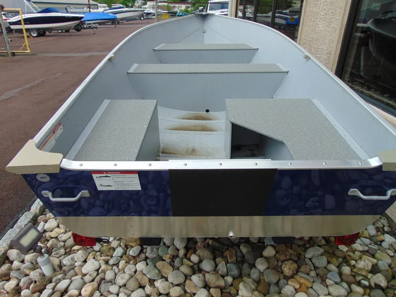 Slide: The Image of 2024 Crestliner 1469 Outreach boat, interior view, parked on rocky surface. - 8