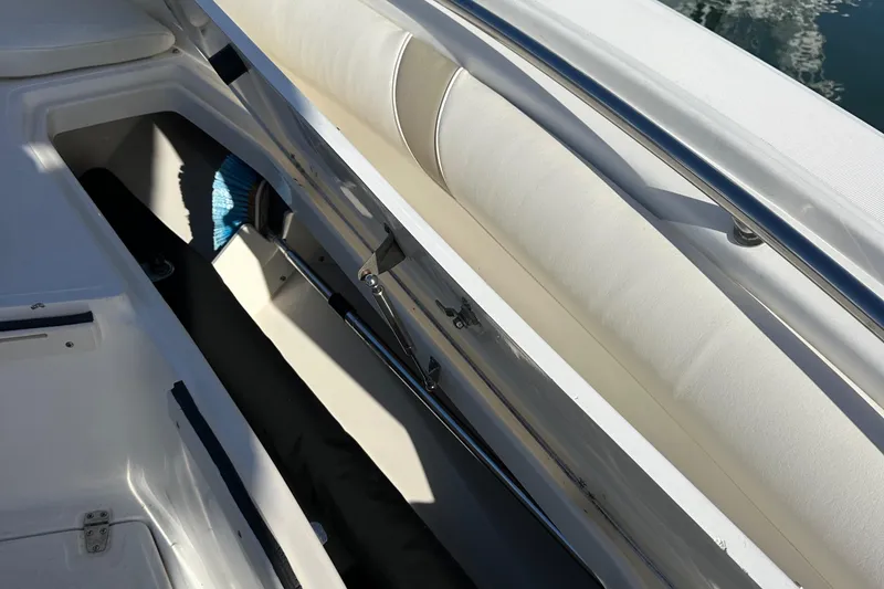 Slide: The Image of 2004 Boston Whaler 270 Outrage boat storage compartment with cushioned seating. - 14