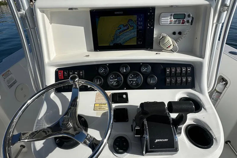 Slide: The Image of 2004 Boston Whaler 270 Outrage dashboard with steering wheel, navigation system, and controls. - 17