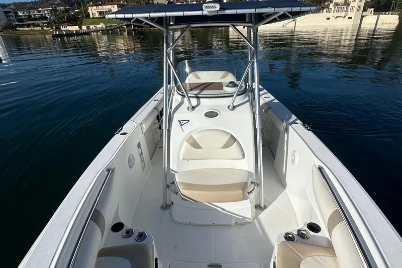 Slide: The Image of 2004 Boston Whaler 270 Outrage boat on calm water, featuring spacious seating and sleek design. - 18