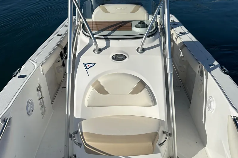 Slide: The Image of 2004 Boston Whaler 270 Outrage boat interior with seating and console, on calm water. - 19