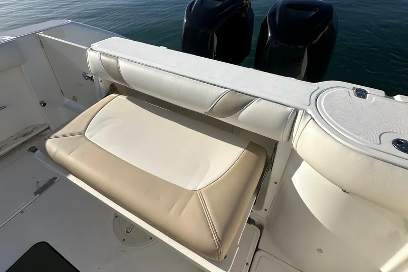 Slide: The Image of 2004 Boston Whaler 270 Outrage boat with cushioned seating and dual outboard motors. - 21