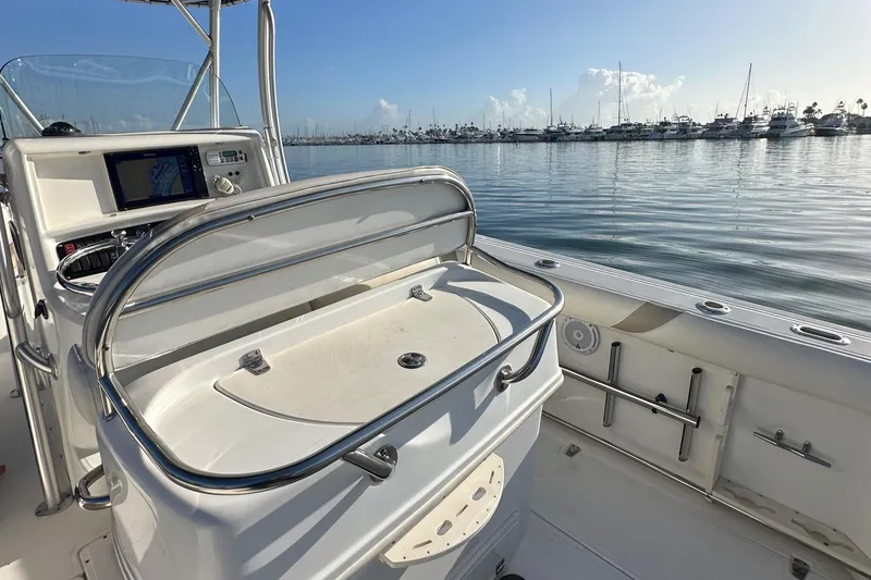 Slide: The Image of 2004 Boston Whaler 270 Outrage boat interior with console, docked in calm marina waters. - 27