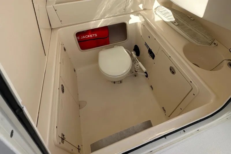 Slide: The Image of 2004 Boston Whaler 270 Outrage boat interior with toilet and life jackets. - 29