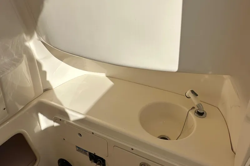 Slide: The Image of 2004 Boston Whaler 270 Outrage interior with sink and storage area. - 30