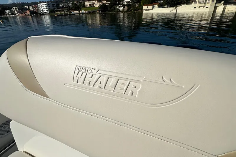 Slide: The Image of Boston Whaler 270 Outrage 2004 boat seat with embossed logo by the water. - 34