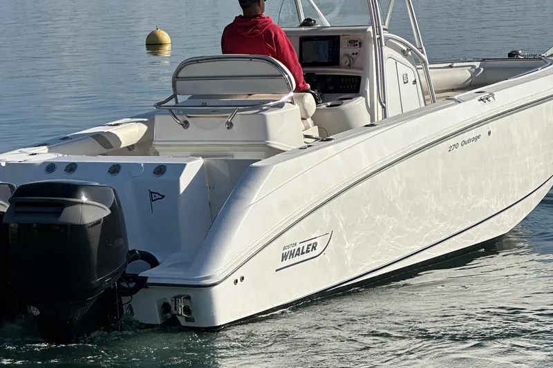 Slide: The Image of Boston Whaler 270 Outrage 2004 boat on water, rear view with person at helm. - 8
