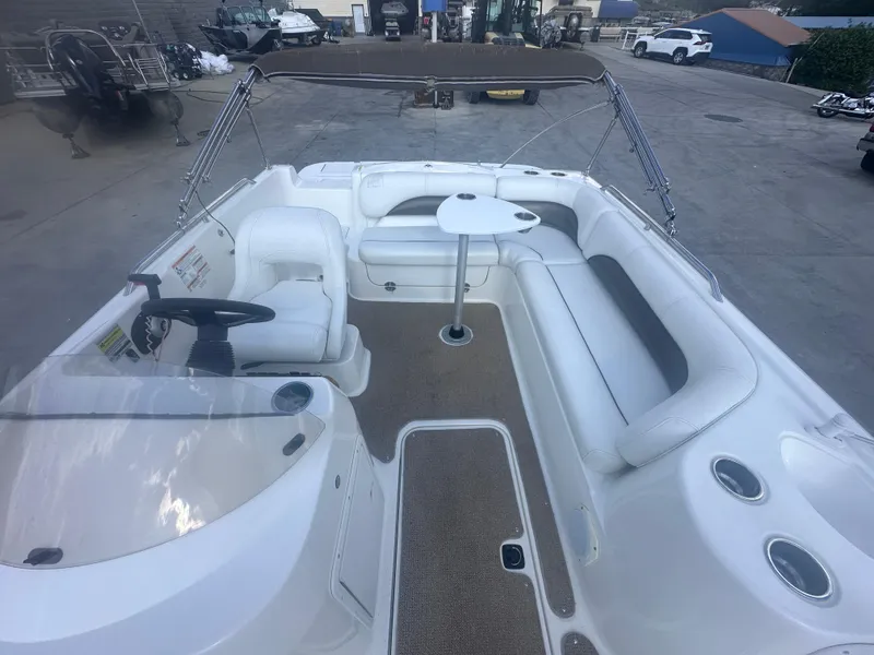 Slide: The Image of 2012 Hurricane SD 201 boat interior with seating, table, and steering wheel in a marina setting. - 11