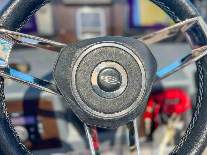Slide: The Image of Steering wheel of 2021 Chaparral 300 OSX boat, featuring sleek design and stitching. - 19