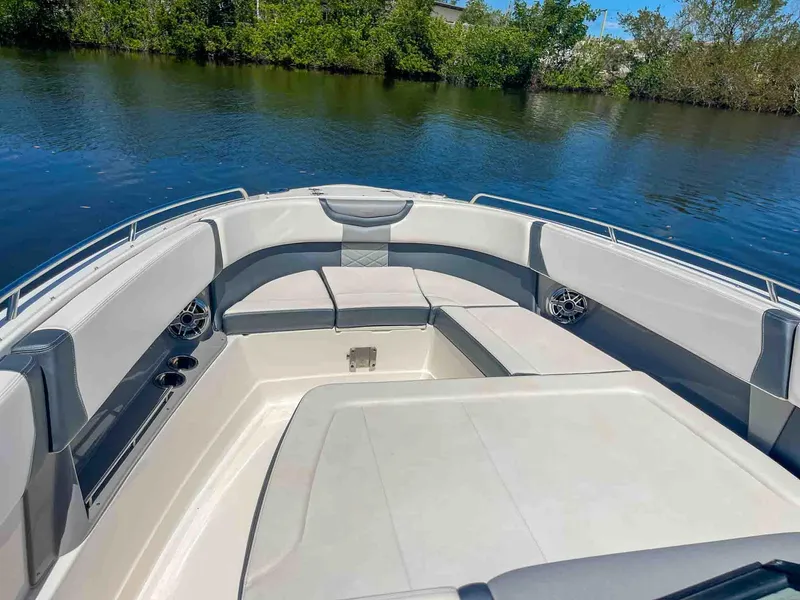 Slide: The Image of 2021 Chaparral 300 OSX boat interior with spacious seating on calm water. - 25