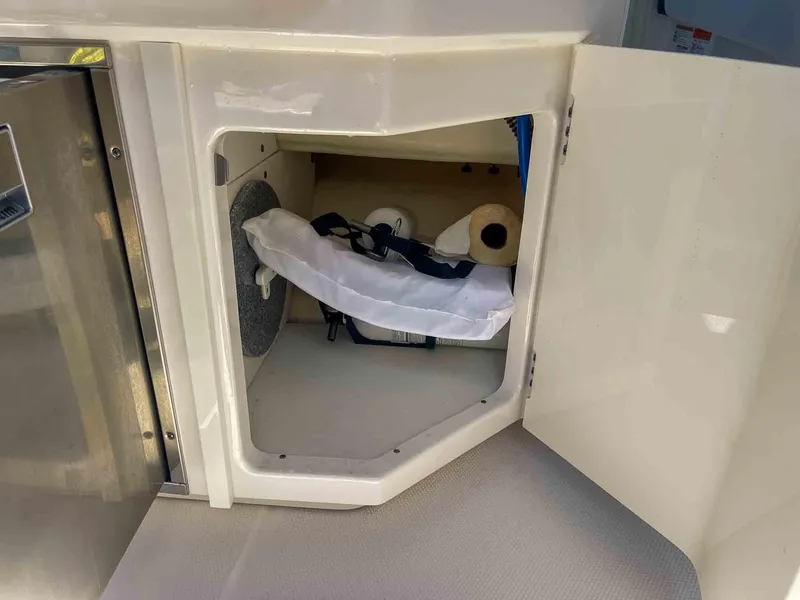 Slide: The Image of Storage compartment on a 2021 Chaparral 300 OSX boat, featuring organized interior space. - 33