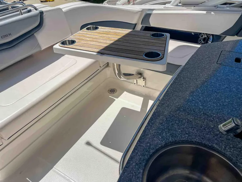 Slide: The Image of 2021 Chaparral 300 OSX boat interior with seating and wooden table. - 43