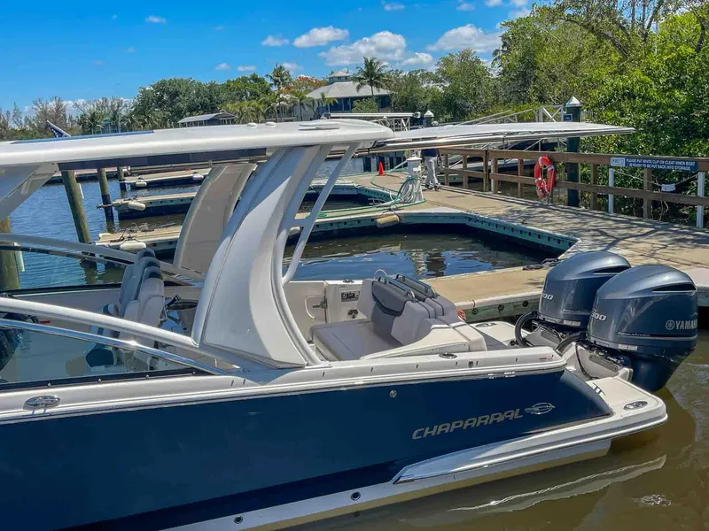 Slide: The Image of 2021 Chaparral 300 OSX boat docked with Yamaha engines, under clear blue sky. - 7