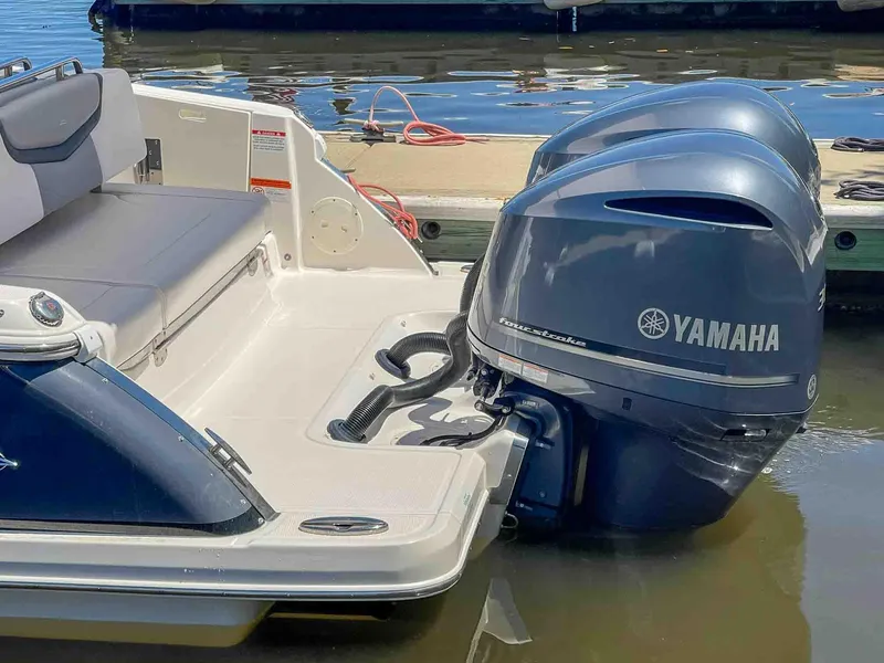 Slide: The Image of 2021 Chaparral 300 OSX boat with Yamaha outboard engines docked by the water. - 8