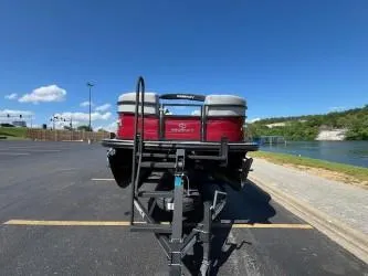 Slide: The Image of 2024 Regency 250 DL3 pontoon boat on trailer by a lakeside parking lot. - 11