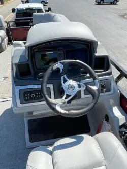 Slide: The Image of 2024 Regency 250 DL3 boat dashboard with steering wheel and navigation system. - 3