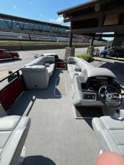 Slide: The Image of 2024 Regency 250 DL3 pontoon boat with spacious seating and modern helm, docked outdoors. - 4