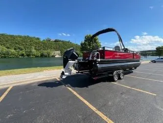 Slide: The Image of 2024 Regency 250 DL3 pontoon boat on trailer by a scenic lake. - 7