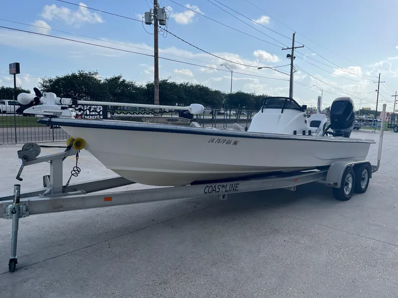 Slide: The Image of 2013 Haynie 24 HO boat on trailer, parked outdoors under a clear sky. - 4